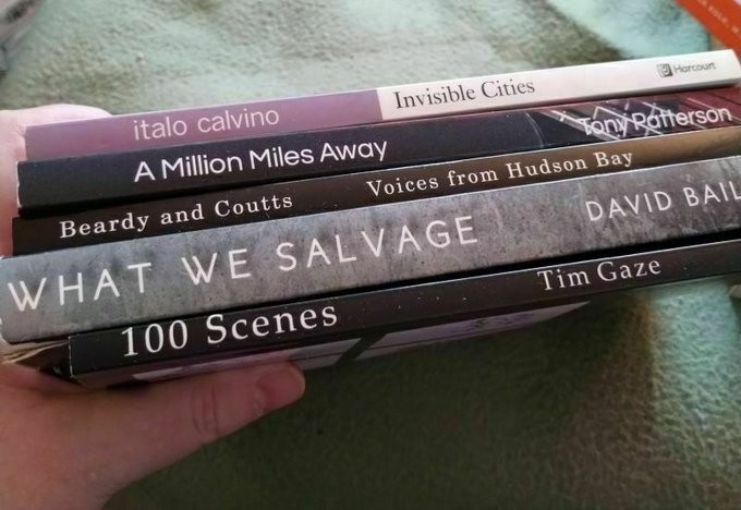 Book pile: Titles from top down: Invisible Cities / A Million Miles Away / Voices From the Hudson Bay / What We Salvage / 100 Scenes